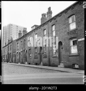 Maisons sur le côté sud de Weller place avec le numéro 2 en premier plan et Scargill Grange tour bloc en arrière-plan, Burmantofts, Leeds, West Yorkshire, Royaume-Uni. Banque D'Images