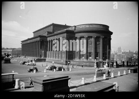 Vue sur le front nord et est de la salle St George, vue du nord, avec une statue sur les marches de la salle, une statue équestre à l'est de la salle, deux coffres en pierre ornementale au premier plan, et une vue sur Liverpool au loin. Banque D'Images