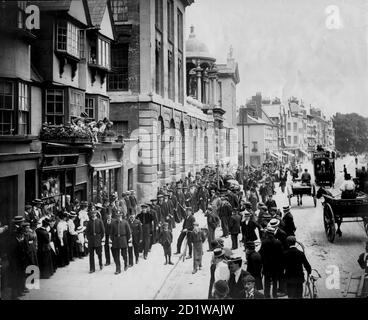 High Street, Oxford, Oxfordshire. Une vue sur la rue High avec Queen's College sur la gauche, montrant la procession de l'Université d'Encaenia sur son chemin au Théâtre Sheldonian pour une cérémonie. Banque D'Images