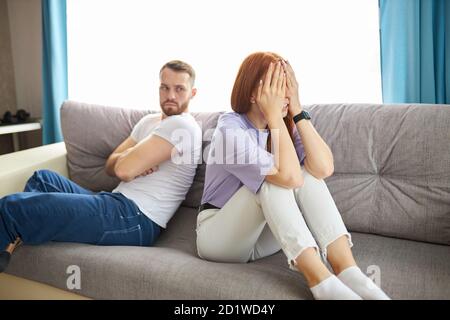 les jeunes couples caucasiens se sont offensés les uns les autres, s'assoient en se détournant les uns des autres, les femmes à tête rouge et les hommes à barbe ont un quarelle, ne parlez pas Banque D'Images