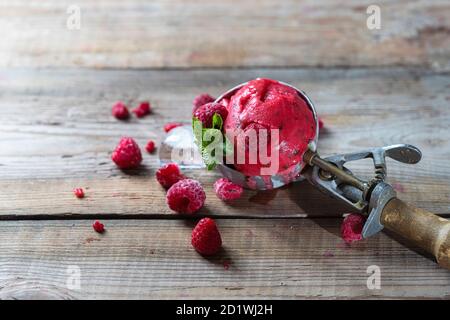 Sorbet framboise, crème glacée sur fond de bois. Cuillère à crème glacée vintage. Copier l'espace. Banque D'Images