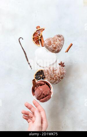 Glace d'hiver avec biscuits au pain d'épice. Les biscuits au pain d'épice et la crème glacée tombent ou volent en mouvement. Banque D'Images