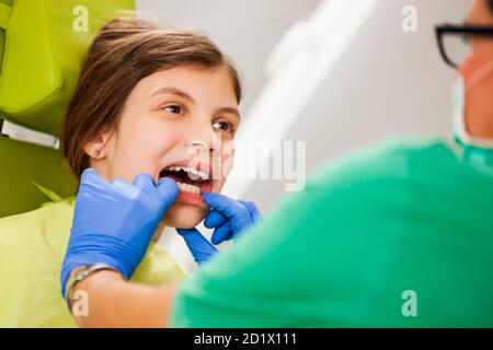 Dentiste examine les dents d'une petite fille. Banque D'Images