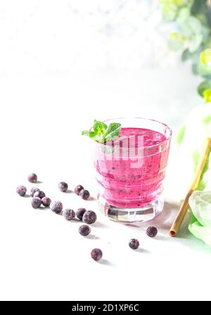 Smoothie vitaminé à partir de baies de cassis avec yaourt et banane dans un verre de cristal. Concept de saine alimentation. Banque D'Images