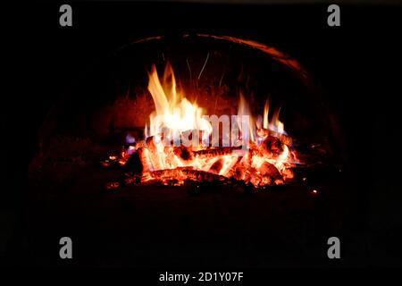 Les billes brûlent dans le four. Flammes et chaleur sur le bois. Hot logs. Banque D'Images