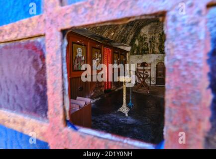 Intérieur de l'église orthodoxe grotte de St Jean l'Hermite dans le monastère abandonné de Katholiko, Crète, Grèce. Prise de vue à travers la fenêtre ouverte. Mise au point sélective. Banque D'Images