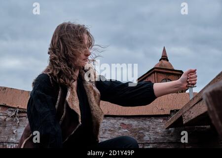 Portrait d'une fille habillée comme un voyou avec un cutlass à bord d'un vieux bateau pirate Banque D'Images