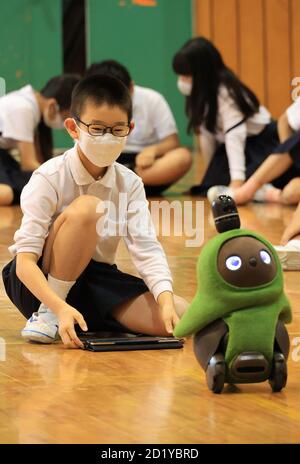 Tokyo, Japon. 6 octobre 2020. Les enfants de sixième année de l'école élémentaire Ouji-daini apprennent la programmation pour faire fonctionner un robot de communication LOVOT, développé par Groove X en utilisant une tablette à leur école à Tokyo le mardi 6 octobre 2020. Le Japon a commencé des cours de programmation informatique dans les écoles primaires compulsorly à partir de cette année pour construire les bases de la technologie de l'information. Credit: Yoshio Tsunoda/AFLO/Alay Live News Banque D'Images