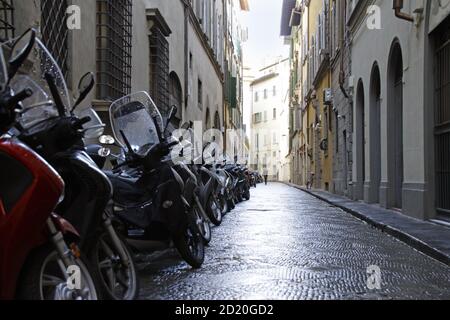 Petite allée avec une rangée de motos garées à Florence, Italie Banque D'Images