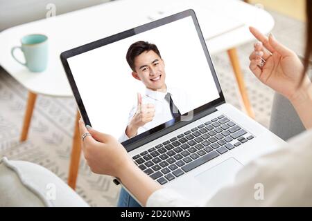 jeune femme d'affaires asiatique travaillant à domicile avec un collègue en ligne par appel vidéo à l'aide d'un ordinateur portable Banque D'Images