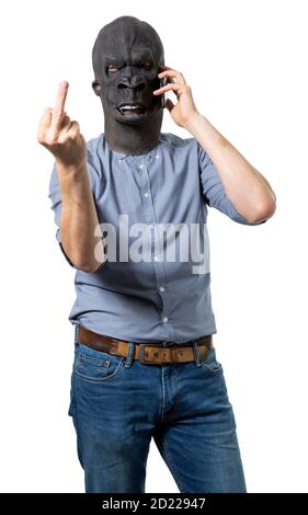 Homme dans le masque de gorille parlant sur le téléphone cellulaire donnant le doigt du milieu. Découpe isolée sur fond blanc. Prise de vue moyenne. Banque D'Images