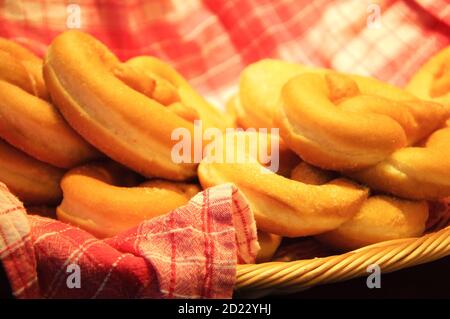 Beignets de bretzel doux sur une serviette à carreaux dans un panier en osier. Banque D'Images