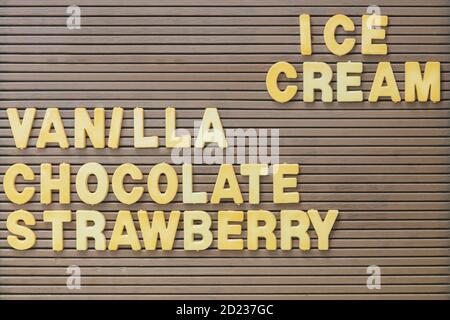 Panneau brun vintage avec le texte jaune crème glacée, vanille, chocolat et fraise Banque D'Images