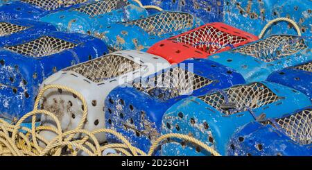 Pots de crabe rouge bleu, rouge et blanc en plastique sur le quai de Mudeford Quay, au Royaume-Uni Banque D'Images