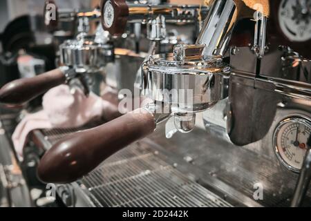 Gros plan sur une machine à café professionnelle. Poignées brunes et surfaces chromées de la machine à café Banque D'Images