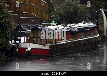 Un bateau sur le canal dans la glace et couvert de neige le long Le magnifique canal de Basingstoke dans le Surrey Banque D'Images