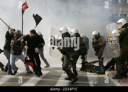 Self-styled anarchists armed with wooden sticks fight against the police in an attempt to release an arrested comrade (on the floor) in a cloud of tear gas outside the Greek Parliament in Athens February 22, 2007. Clashes erupted after protesters tried to break a police cordon as thousands of students marched through Athens to protest government plans to reform higher education and introduce private universities.    REUTERS/Yannis Behrakis (GREECE)
