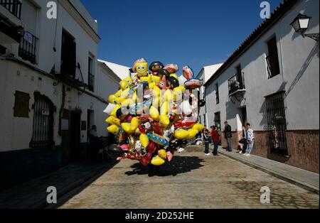 A seller holds a cluster of balloons during the annual San Antonio Abad (Saint Anton Abbott) festival in Trigueros, near Huelva, southwest Spain January 24, 2010. Thousands of people arrived in Trigueros to participate in this annual catching for food and presents, part of the traditional three-day religious festival. REUTERS/Marcelo del Pozo (SPAIN - Tags: SOCIETY RELIGION)