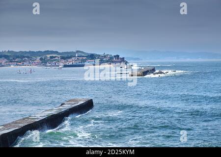 Saint Jean de Luz, France. Pays Basque. Vue sur la ville de Ciboure et le château et le port de Socoa. Voiliers. Des vagues de l'océan se brisent autour du barrage Banque D'Images