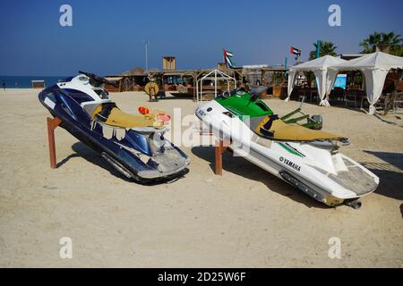 Deux jet ski colorés stationnés sur la plage de la saison des vacances. Vieux jet skis sur la plage sur remorque en bois. Blue and White Jet ski - Dubaï eau 20 janvier Banque D'Images