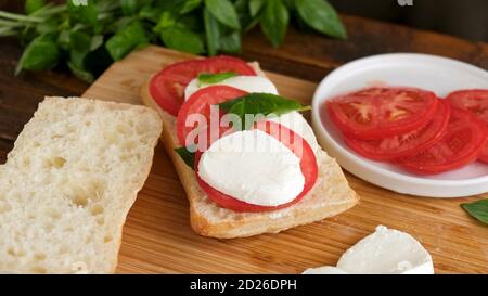 Sandwich Panini Caprese sur bois. Hors-d'œuvre italien Banque D'Images