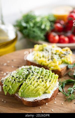 Toast à l'avocat, au fromage à la crème et aux graines de sésame pour un petit déjeuner sain ou un en-cas Banque D'Images