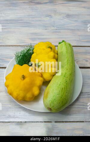 Récoltez des courgettes et des mini-patty sur une table en bois de près. Banque D'Images