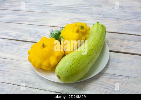 Courgettes vertes et mini-patty jaune écrase sur fond de bois. Légumes de récolte d'automne. Banque D'Images