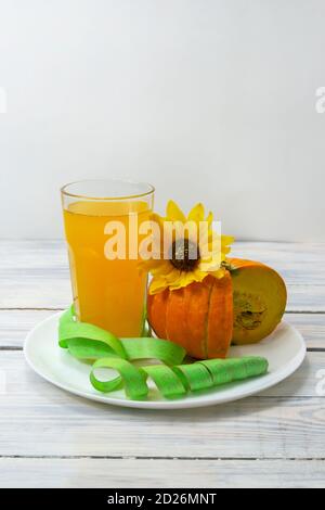 Smoothie potiron pour la perte de poids. Jus de citrouille frais en verre sur fond de bois. Vue latérale, mise au point sélective. Banque D'Images