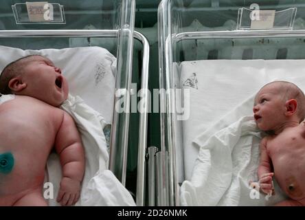 Baby girl Nadia (L), who weighed 7.75 kg (17.1 lbs) after birth, lies in a maternity ward in the Siberian city of Barnaul September 26, 2007. One Siberian mother has done more than her fair share to heal Russia's dire population decline. Tatyana Khalina shocked her husband by giving birth to a 7.75 kg (17.1 lbs) baby girl this month, her 12th child.  REUTERS/Andrey Kasprishin (RUSSIA)