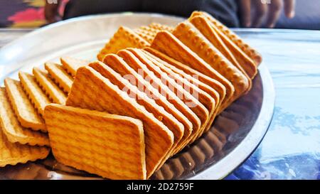 Biscuits de blé dans la plaque d'acier avec fond de noir. Biscuits indiens communément connus sous le nom de Chai-biscuit en Inde Banque D'Images