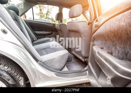 Rangée de sièges arrière de passager rembourrée en tissu gris foncé nettoyé à sec; préparation avant la vente d'une vieille voiture japonaise. Banque D'Images
