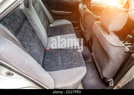 Rangée de sièges arrière de passager rembourrée en tissu gris foncé nettoyé à sec; préparation avant la vente d'une vieille voiture japonaise. Banque D'Images