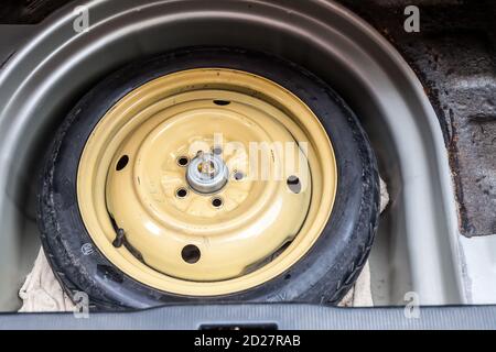 Roue de secours dans le coffre de la voiture d'occasion. Industrie de l'auto-service. Catalogue de pièces de voiture. Entrepôt de junkyard Banque D'Images