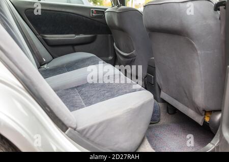 Rangée de sièges arrière de passager rembourrée en tissu gris foncé nettoyé à sec; préparation avant la vente d'une vieille voiture japonaise. Banque D'Images