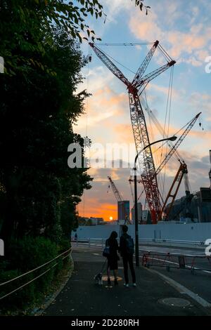 Le soleil se couche derrière le chantier de construction du stade national du Japon. Banque D'Images