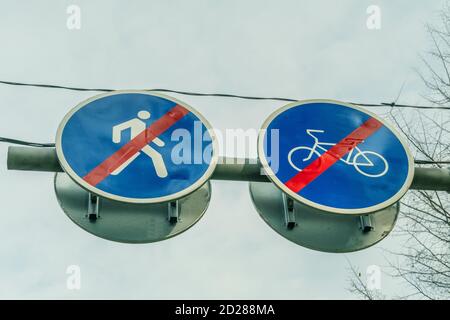 Deux panneaux routiers côte à côte pour piétons et cyclistes gros plan contre le ciel et les branches de l'arbre montrant cela le drive and pass est terminé Banque D'Images