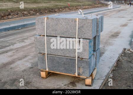 Beaucoup de bordures pour travaux de construction sur palettes sur le site pose de pavés carrés urbains Banque D'Images