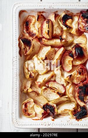 Tranches de pomme cuites à la cannelle dans un plat de cuisson. Banque D'Images