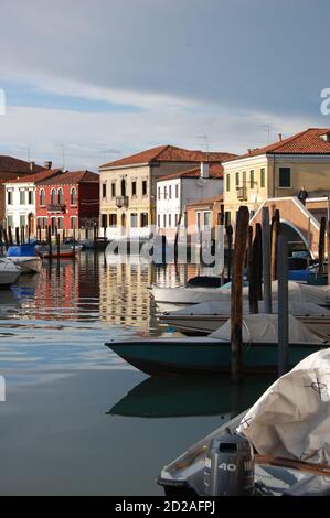 Venise, île de Burano, vue sur un canal dans l'après-midi lumière, ciel clair et sombre après une tempête, traditionnelles vénitiennes façades peintes reflet Banque D'Images