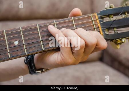 Gros plan de la main d'un guitariste sur une guitare acoustique. Main du joueur de guitare sur le tableau de bord d'une guitare acoustique gros plan Banque D'Images