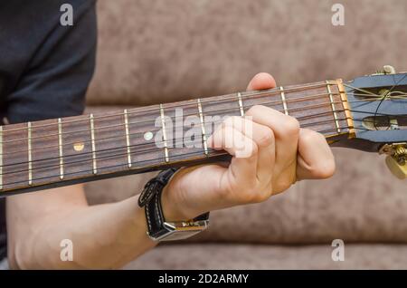 Gros plan de la main d'un guitariste sur une guitare acoustique. Main du joueur de guitare sur le tableau de bord d'une guitare acoustique gros plan Banque D'Images