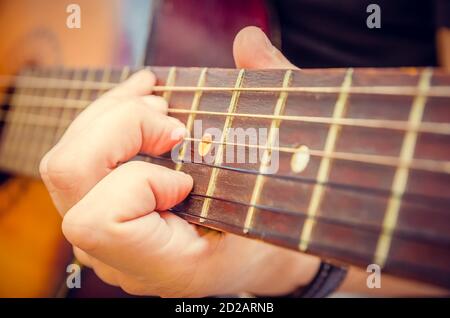 Gros plan de la main d'un guitariste sur une guitare acoustique. Main du joueur de guitare sur le tableau de bord d'une guitare acoustique gros plan Banque D'Images