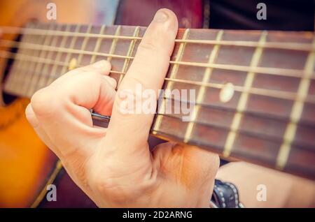 Gros plan de la main d'un guitariste sur une guitare acoustique. Main du joueur de guitare sur le tableau de bord d'une guitare acoustique gros plan Banque D'Images