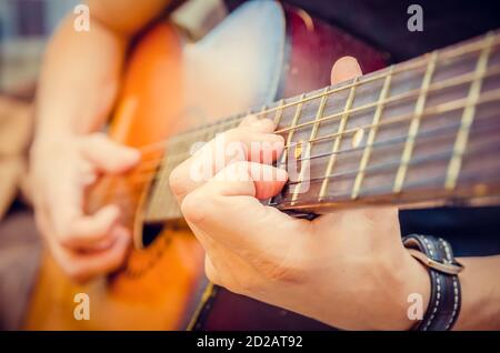 Gros plan de la main d'un guitariste sur une guitare acoustique. Main du joueur de guitare sur le tableau de bord d'une guitare acoustique gros plan Banque D'Images