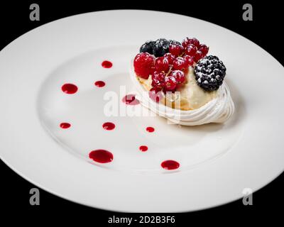 Délicieux gâteau aux baies : raisins de Corinthe, bleuets, mûres. Crème et belle forme. Dessert au restaurant. Nourriture. Isolé sur ba noir Banque D'Images