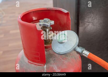 Flexible de raccordement avec clapet à la bouteille de gaz, gros plan de la bouteille de gaz rouge Banque D'Images
