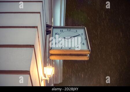 Horloge carrée accrochée sur le mur sur la rue dans la soirée, copier l'espace Banque D'Images