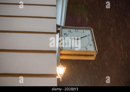 Horloge carrée accrochée sur le mur sur la rue dans la soirée, copier l'espace Banque D'Images