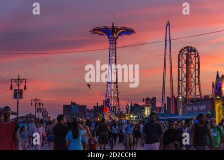 Un homme saute à l'élastique de la Tour à Coney Island lors d'une soirée d'été bondée. Photo par Liz Roll Banque D'Images